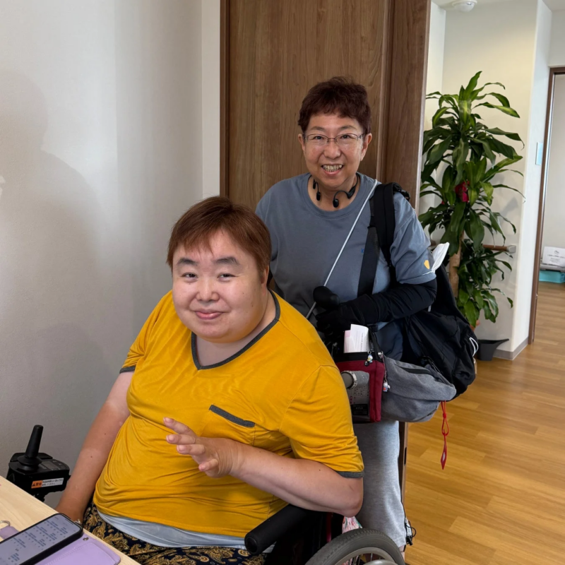 車椅子に座る女性と隣に立つ女性