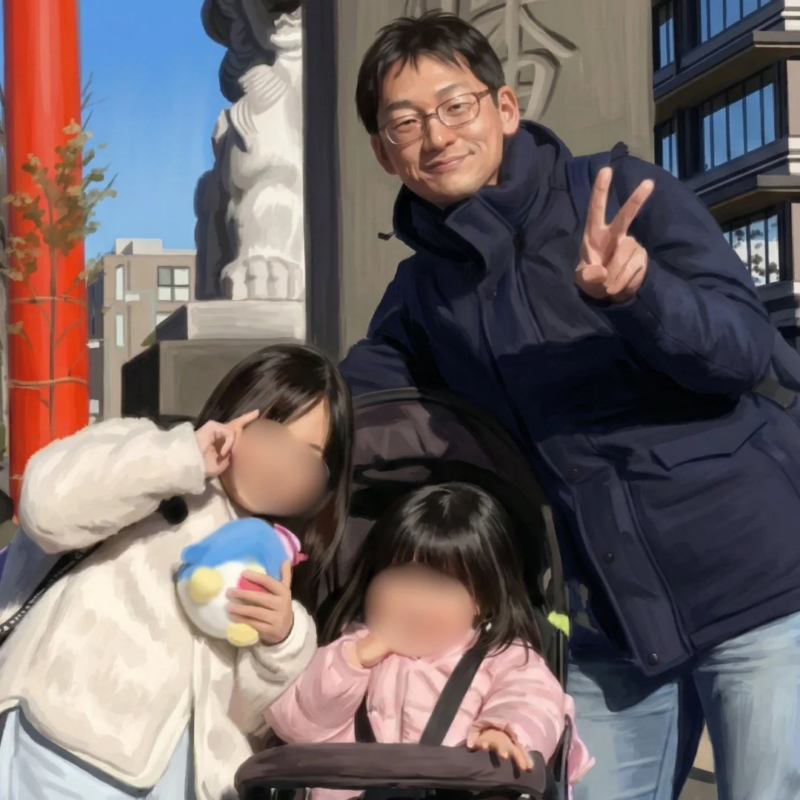 父親と2人の娘が屋外で笑顔でポーズをとっている家族写真