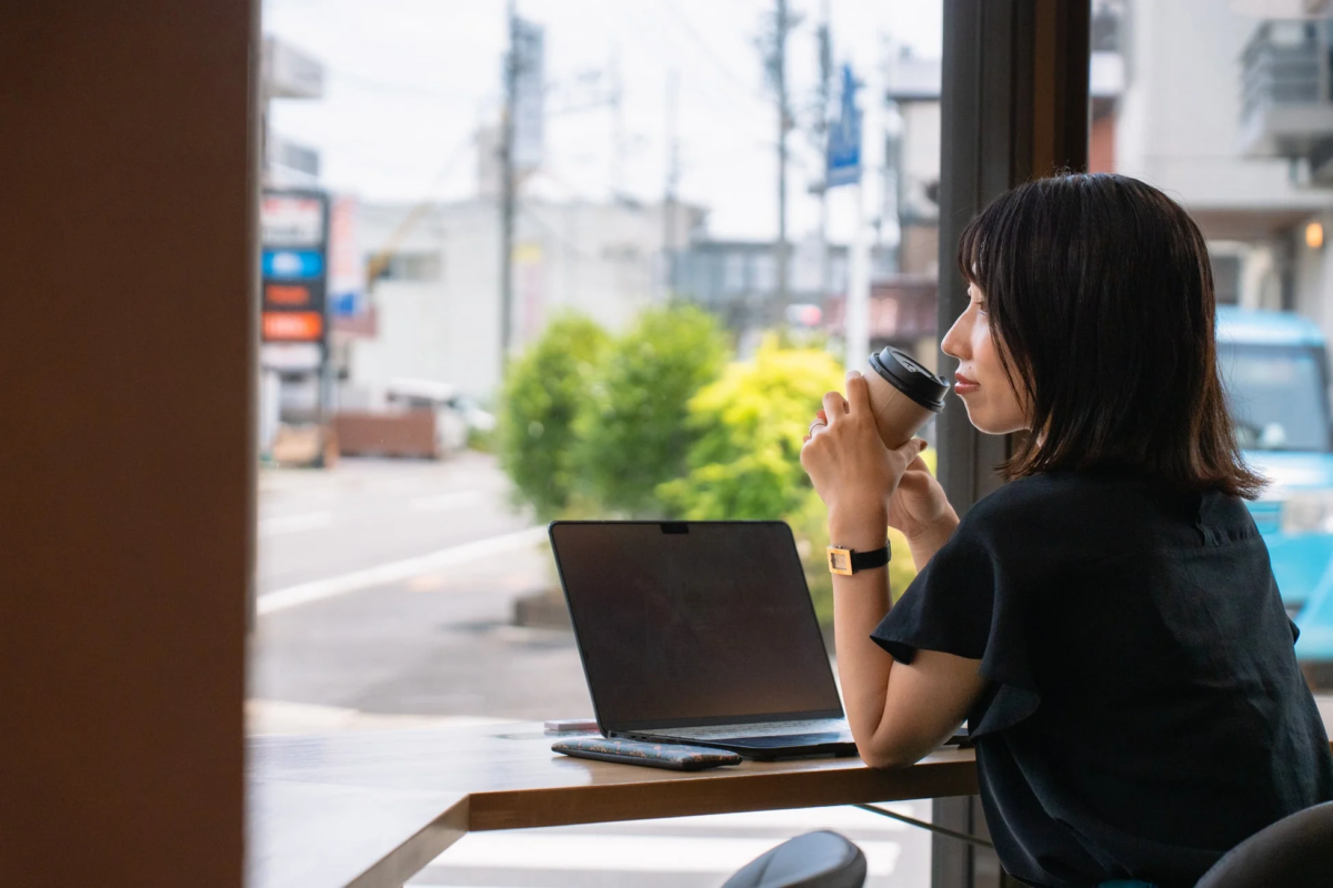 窓際でノートパソコンを使う女性