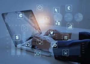 ノートパソコンを使用する人物の周りに、金融、ビジネス、データ分析などを象徴する様々なデジタルアイコンが浮かんでいる様子が描かれており、デジタルビジネスやテクノロジーの活用を示唆しています。