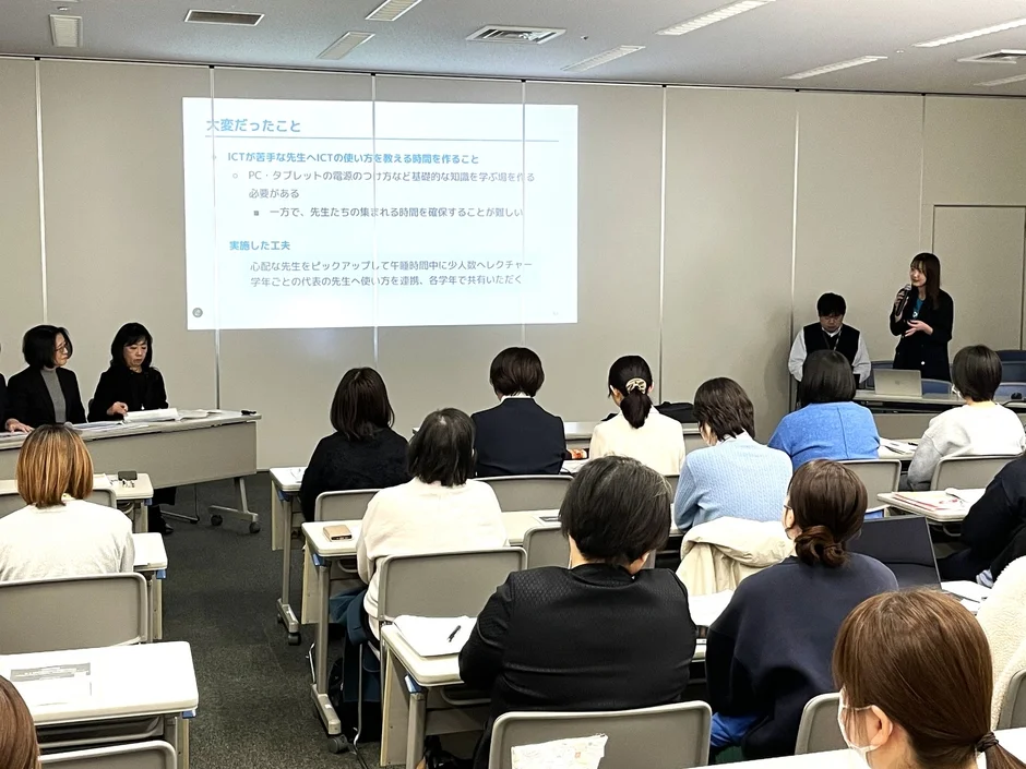 教室で大勢の参加者がプレゼンテーションを聞いている様子