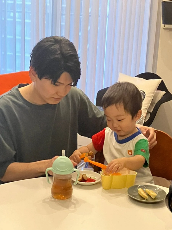 男性と幼児がテーブルで食事をしている様子