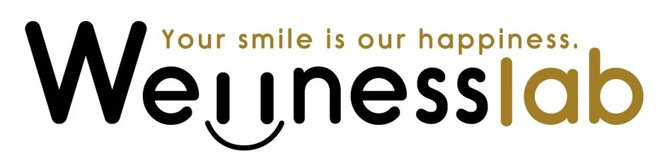 「Wellnesslab」という文字と「Your smile is our happiness.」というスローガンが書かれたロゴ画像です。「Wellnesslab」の「u」の部分が笑顔のマークになっています。