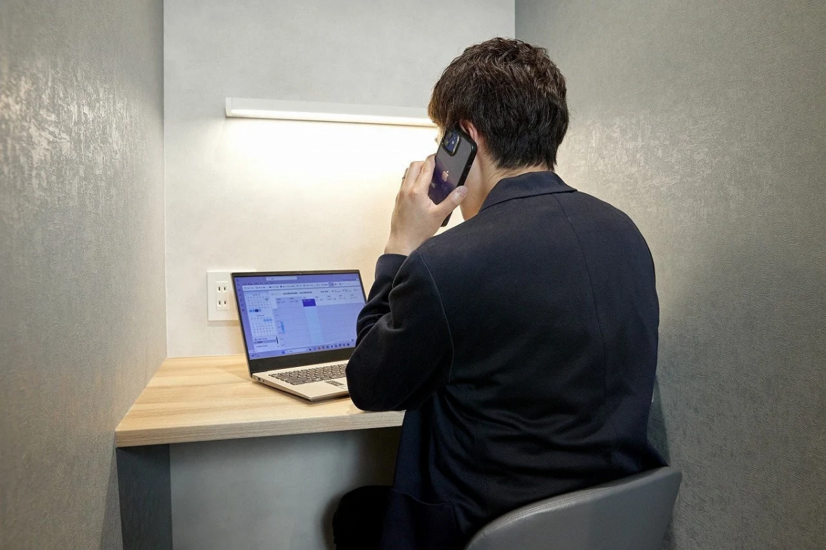 個室ブースで仕事をする男性の後ろ姿