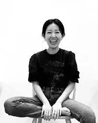 笑顔で座る藤原祥子氏のモノクロ写真