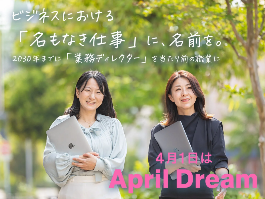 屋外でノートPCを抱えて笑顔の2人の女性