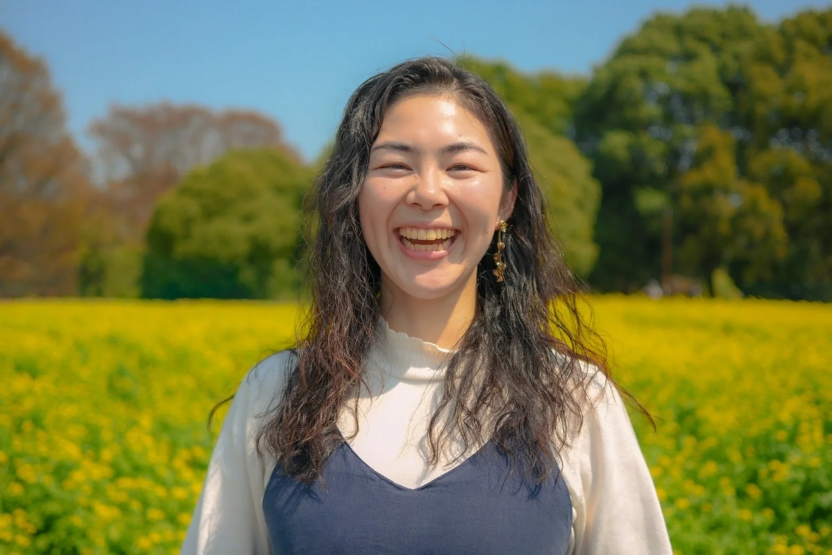 菜の花畑で笑顔を見せる女性