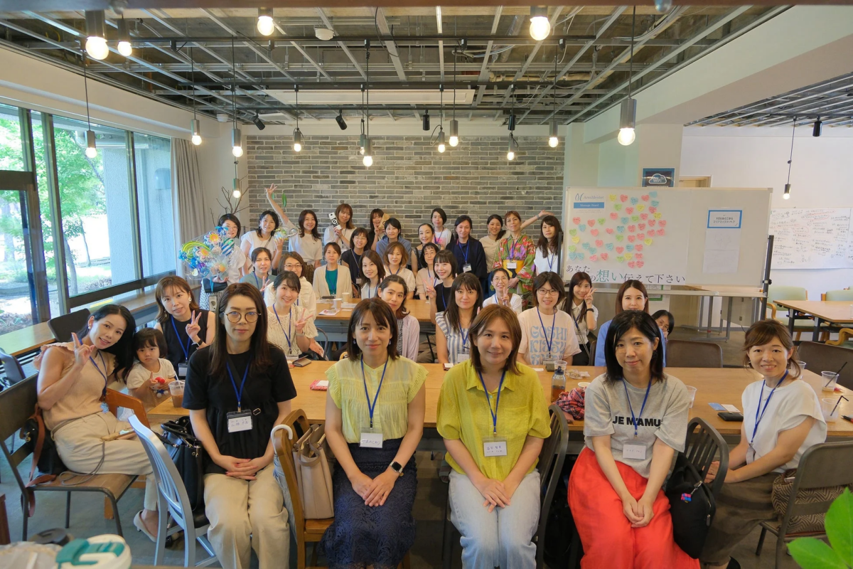 多くの女性たちが笑顔で集合写真に収まっている様子