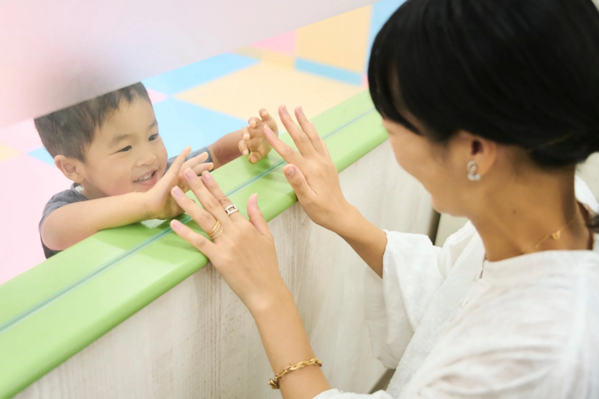 ガラス越しに触れ合う親子