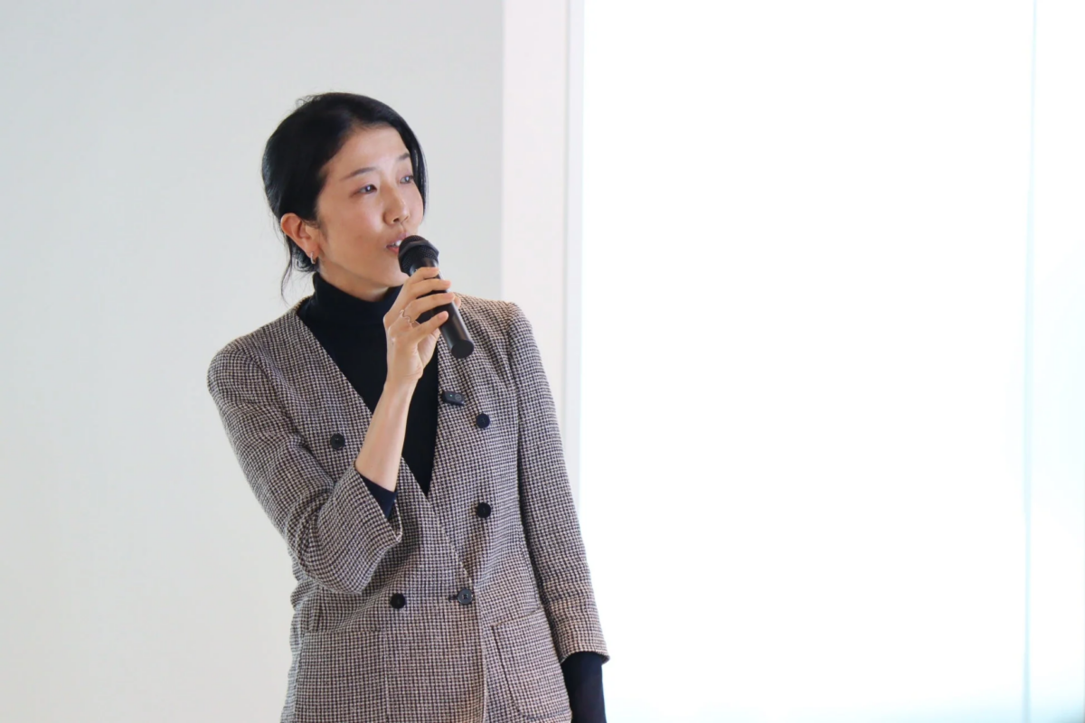 マイクを持って話す日本人女性