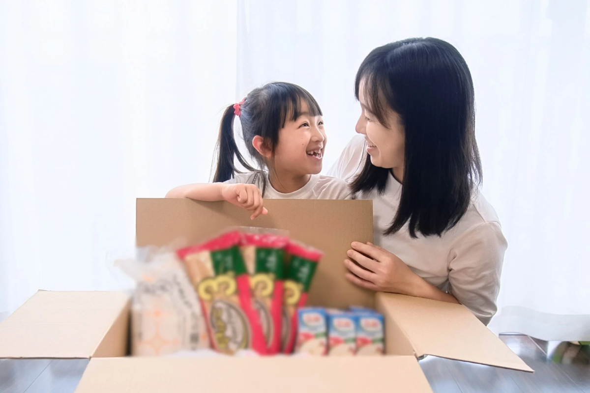 段ボール箱を覗き込み笑顔の親子