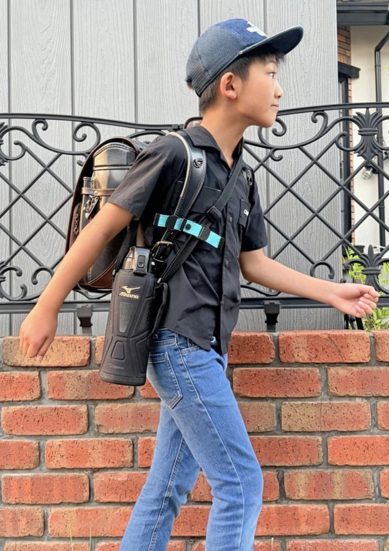 ランドセルを背負い、水筒を下げた少年