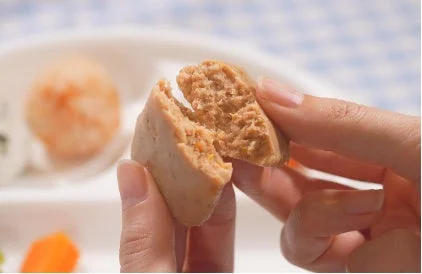 女性の手が丸い食べ物を半分に割る様子